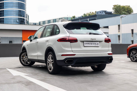 White SUV porsche cayenne diesel on a city street singapore